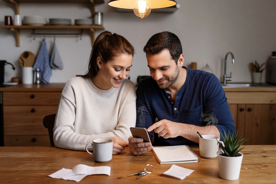 Couple reviewing shared household budget on a tablet using a budgeting app