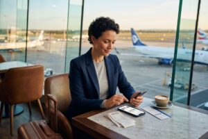 Business owner using an expense tracking app on a smartphone while traveling