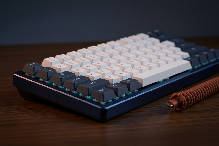 Keychron Q1 Pro mechanical keyboard on a programmer's desk with code on screen