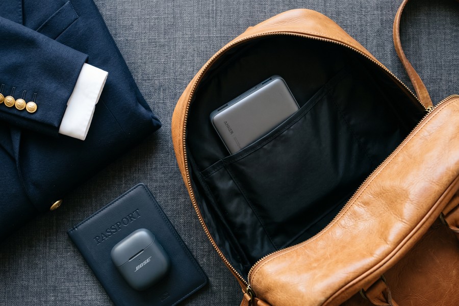 Side-by-side comparison of slim Baseus Blade and high-capacity Anker 737 power banks on a travel bag