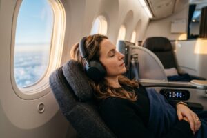 Traveler wearing travel noise-canceling headphones on a long-haul flight