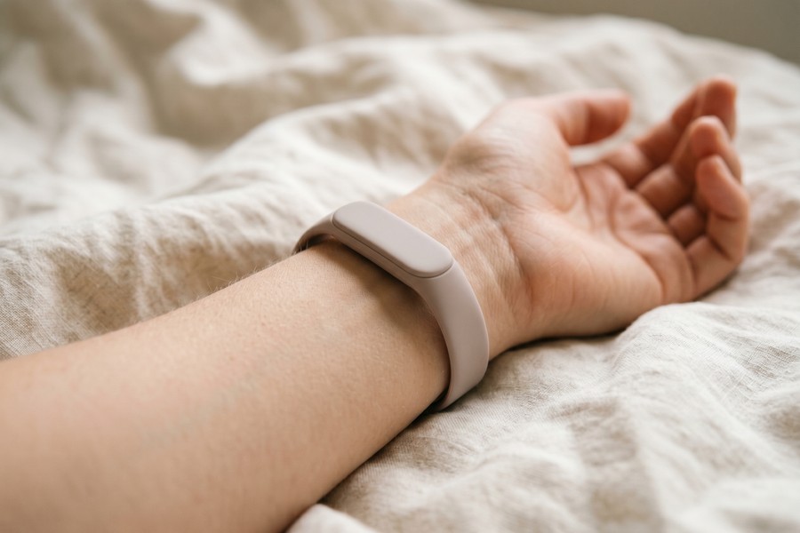 Slim fitness tracker worn during sleep versus bulkier smartwatch removed for charging