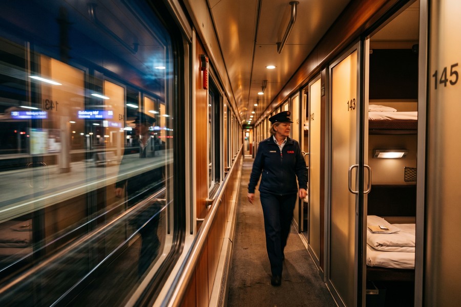 A modern Nightjet sleeper compartment interior with fold-down beds and reading lights