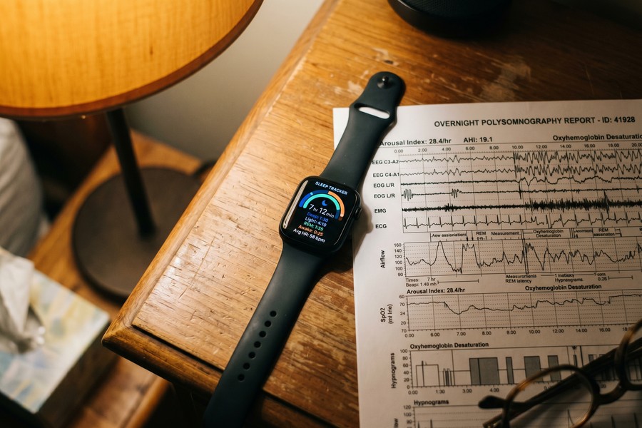 Close-up of an Oura Ring Gen 4 worn by a nurse next to a sleep data dashboard