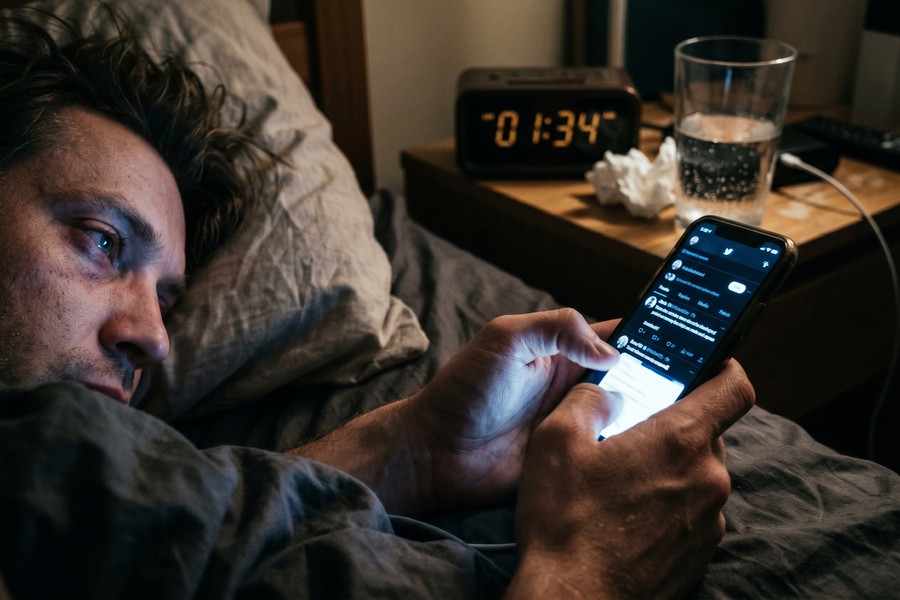 Sunrise simulation alarm clock glowing softly on a nightstand in a darkened bedroom