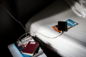 A traveler using a power bank on an airplane with a laptop and phone