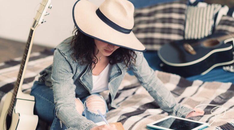 A travel journal with a built-in phone stand open on a plane seat