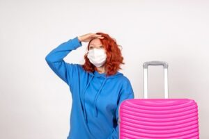 Traveler with medication case, smartphone showing health app, and passport on desk