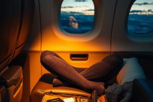 Traveler wearing compression socks during long-haul flight with laptop on lap