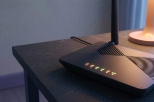 Modern Wi-Fi router on a desk with electricity usage meter display