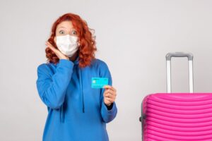 A traveler using a credit card to get free travel insurance