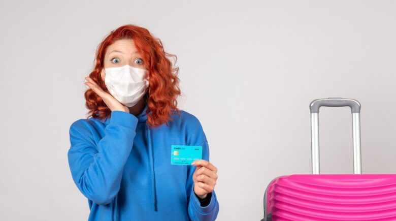 A traveler using a credit card to get free travel insurance