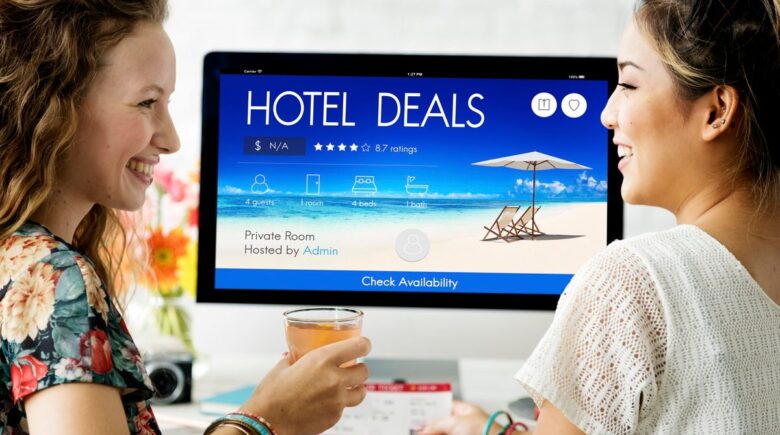 A person holding a hotel keycard with a rooftop view, smiling