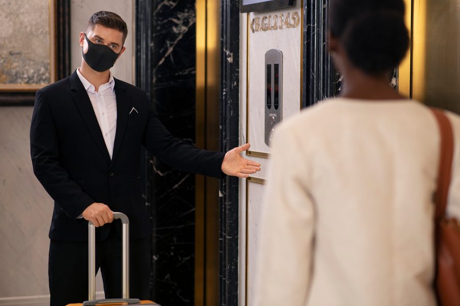 A traveler receives a hotel key at check-in, labeled as a rooftop suite.