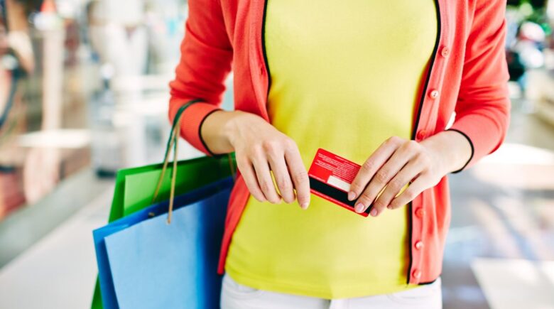 A person using a travel-only credit card for everyday purchases at a grocery store