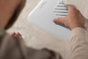 A traveler using an air vent pillow during a long flight to stay cool