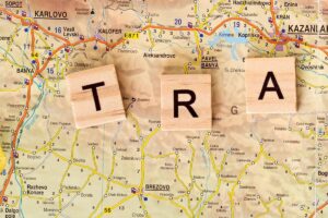 Split view of smartphone with compass app and folded paper travel map side by side
