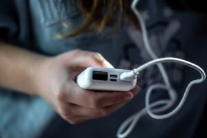 Portable phone charger next to European electrical outlets and luggage