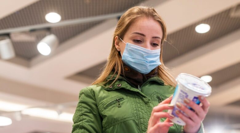 A traveler packing a reusable food container in their carry-on luggage at the airport