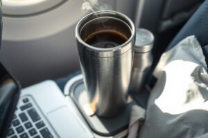 Self-heating travel mug being used during a flight with a coffee inside