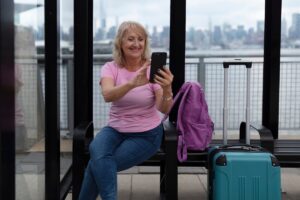 Digital smart luggage scale displaying weight with smartphone app connected via Bluetooth