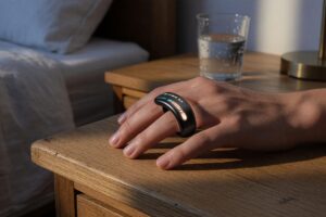 Woman wearing a black smart ring checking health data on her phone