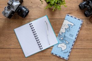 A small notebook with gel pen sitting on a travel notebook cover