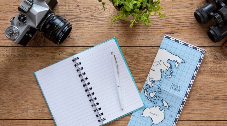 A small notebook with gel pen sitting on a travel notebook cover