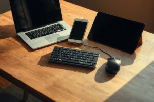 Austin freelancer with three portable workstation gadgets: laptop, e-ink tablet, and Thunderbolt dock arranged on a desk